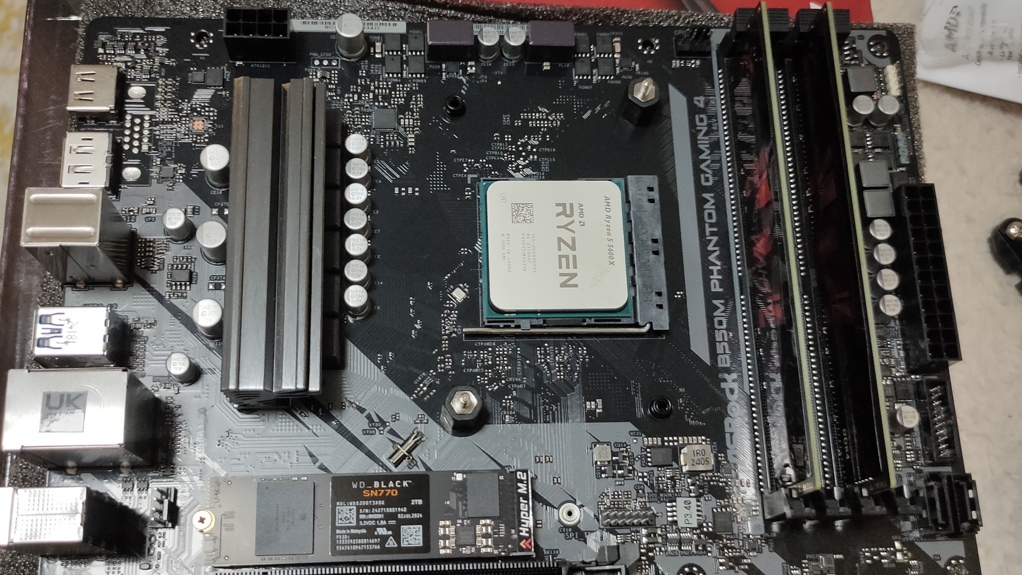 Un processeur Ryzen 5 5600X à l'intérieur d'une carte mère B550M avec du RAM DDR4 et un SSD NVME.