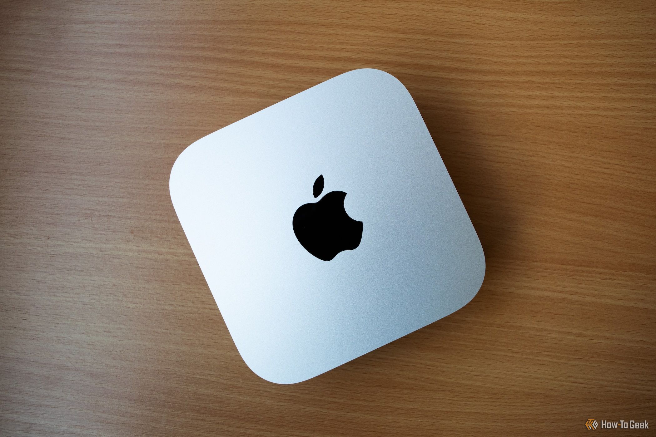Un M4 Mac Mini assis sur une table en bois. 