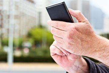 Les mains touchent l'écran sur un téléphone portable moderne