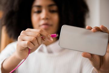 Personne connectant le câble au téléphone portable