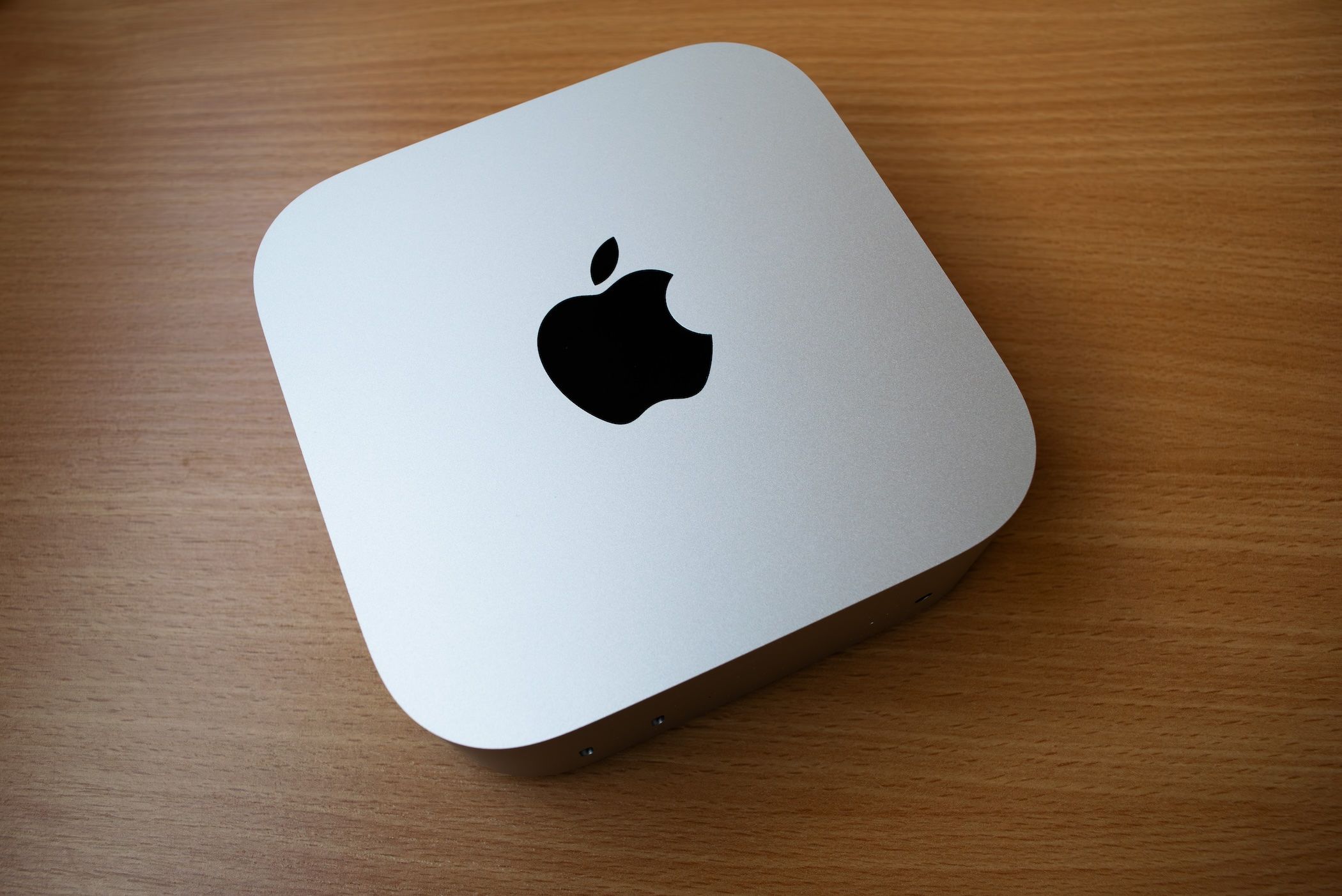 Un M4 Mac Mini assis sur une table en bois. 