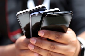 Un participant tient une pile du nouveau Google Pixel 3A lors de la conférence Google d'E / S 2019